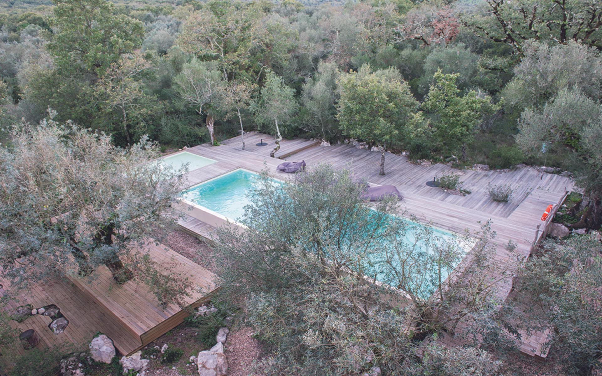 STRÅLANDE UTSIKTER. Från takterrassen på Villa Pedra blickar du ut över bergen i fjärran, vackra lövträd och poolen med sitt perfekt turkosa vatten.