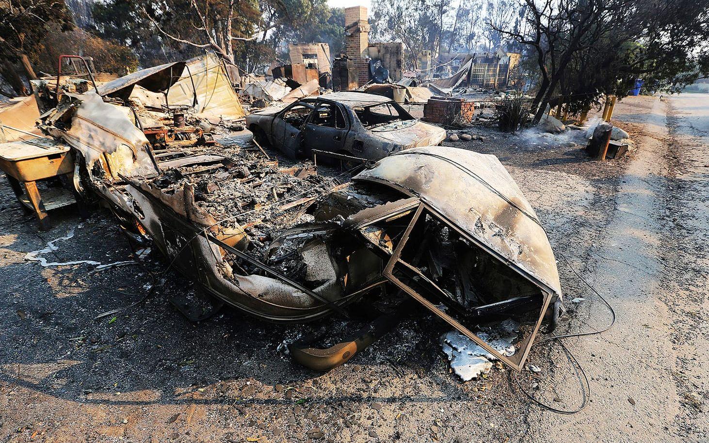 Fordon och ett hem i ruiner på Windermere Drive i Point Dume-området i Malibu, Kalifornien. Skogsbranden the Woolsey Fire har ödelagt minst 20 hem i området.