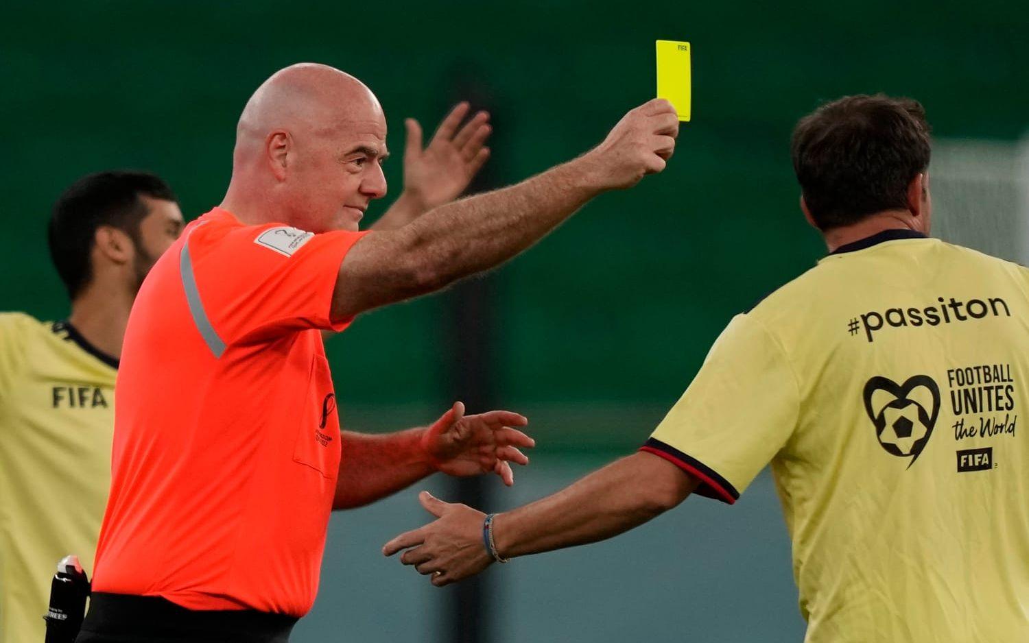 Fifas ordförande Gianni Infantino drar fram det gula kortet under en uppvisningsmatch vid VM i Qatar 2022.