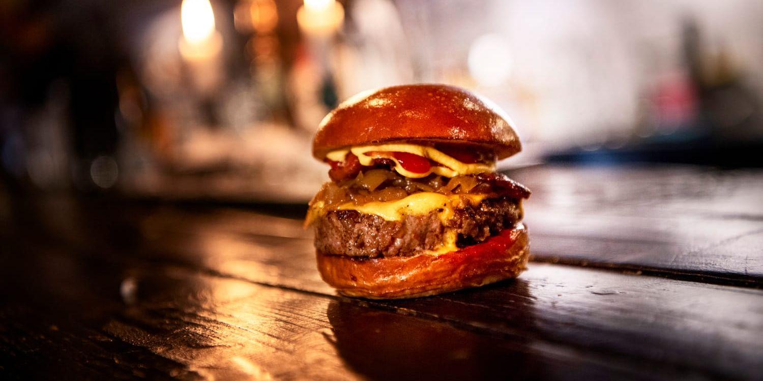 En hamburgare på ett svartmålat träbord.