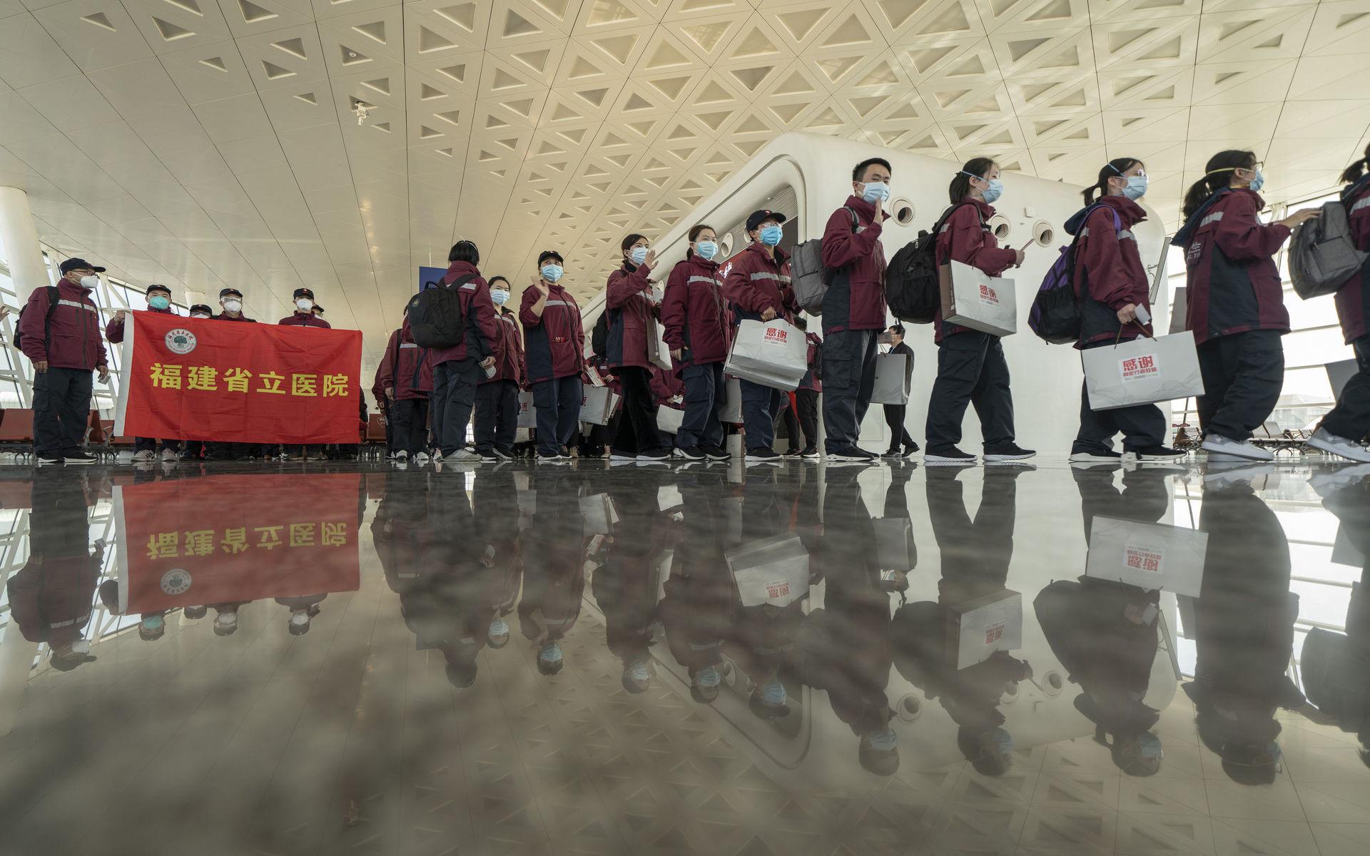 I en bild från den 18 mars som släppts av den kinesiska nyhetsbyrån Xinhua News Agency visar hur medicinsk personal gör sig redo att gå ombord ett flygplan på Wuhan Tianhe Airport. 