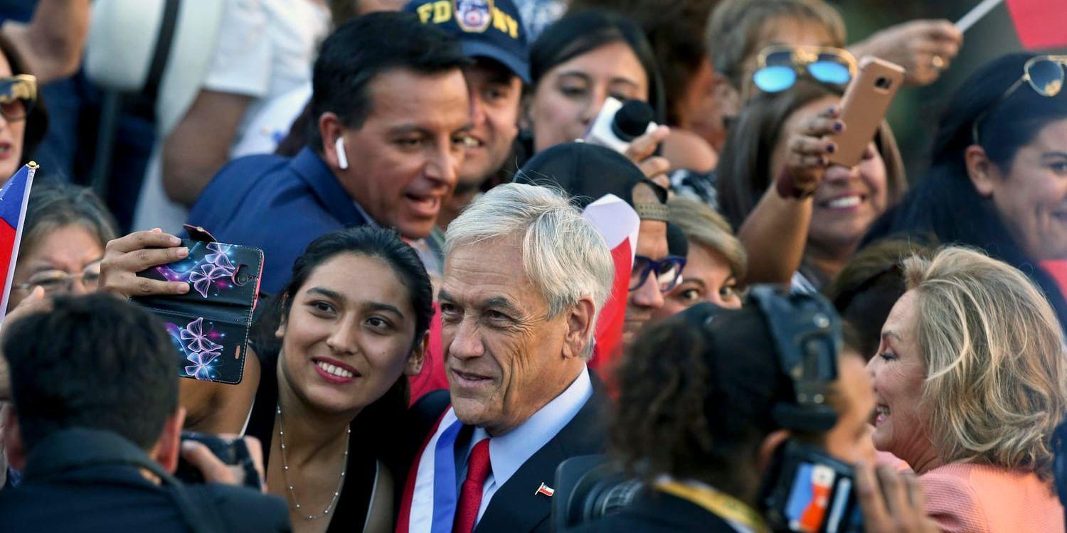 Sebastián Piñera poserar med en anhängare.