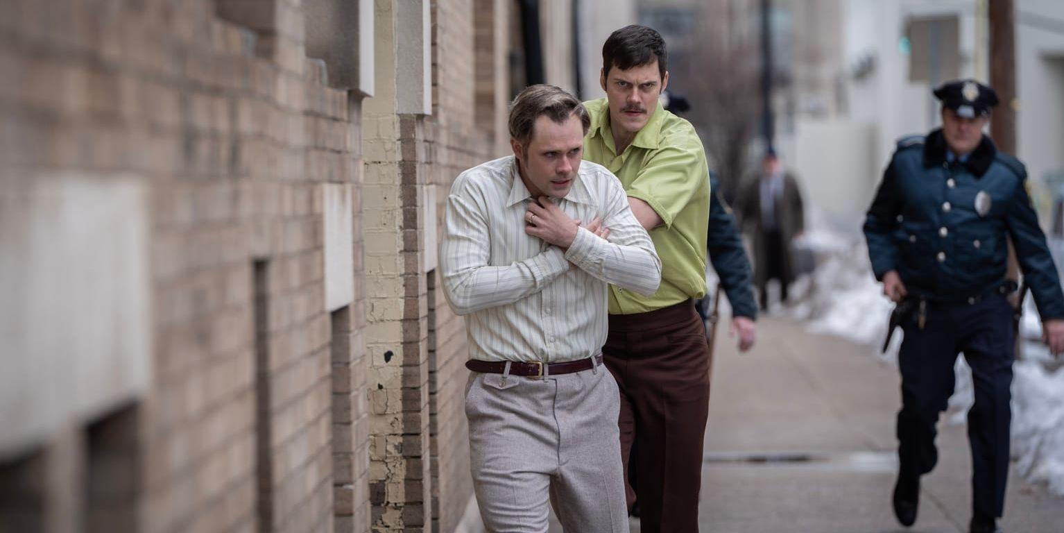 Bill Skarsgård i rollen som gisslantagare skjuter sitt offer framför sig på en gata.