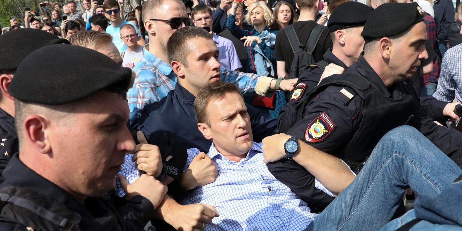 Den ryske oppositionsledaren Aleksej Navalnyj förs i väg av polis under en protest i Moskva.