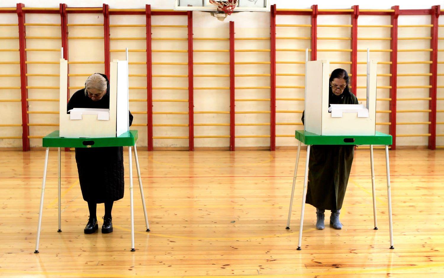 Kvinnor fyller i sina röstsedlar i en vallokal i Tbilisi.