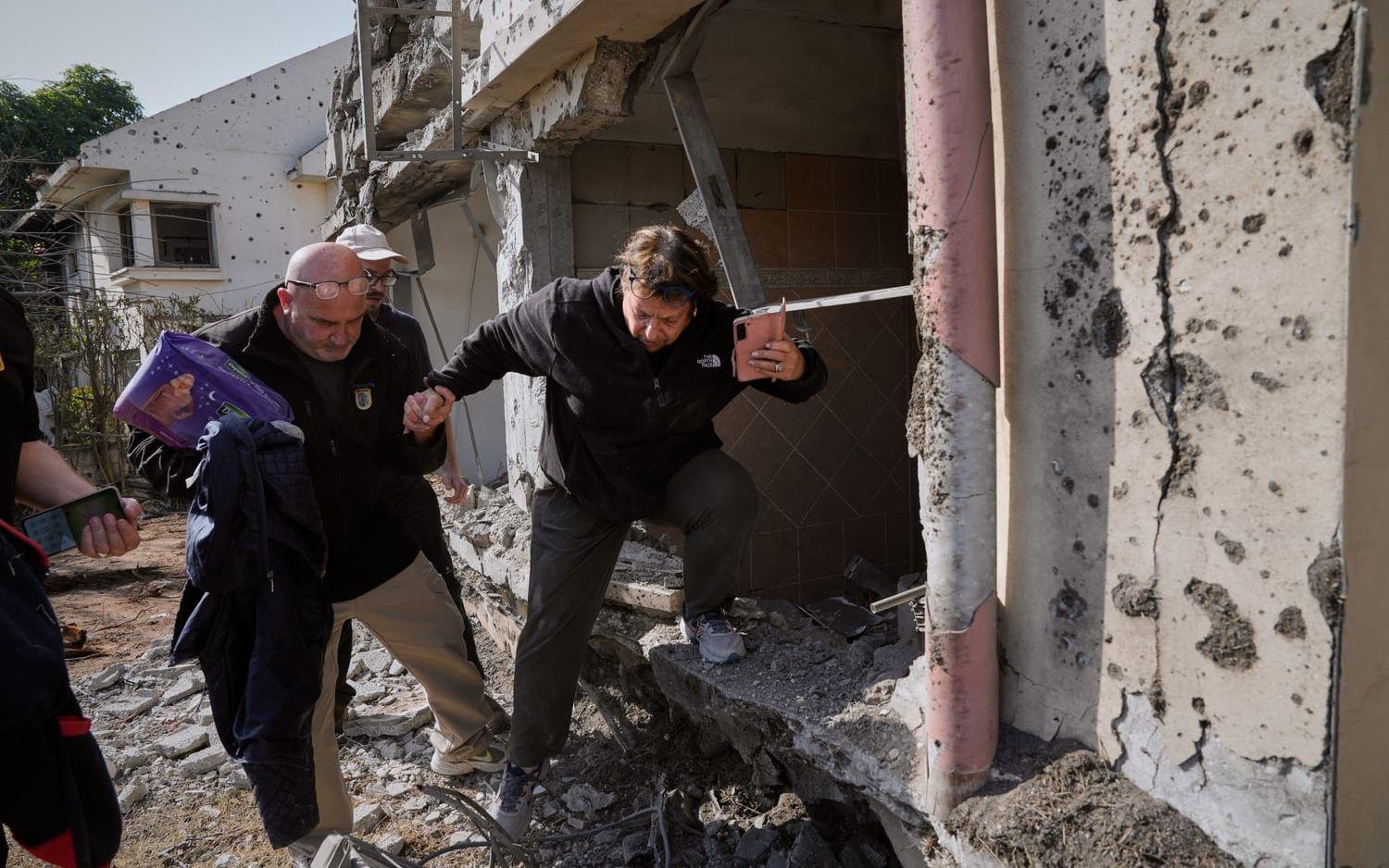 En kvinna hämtar tillhörigheter i sitt hem i Haniel i Israel, efter att en raket slagit ned och förstört bostaden.