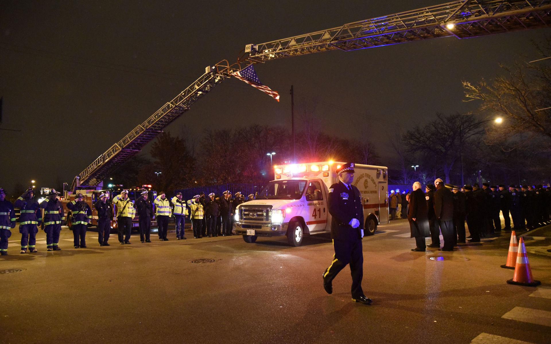 Poliser och brandmän formerade sig en så kallad hedersvakt kring den ambulans som förde bort den ihjälskjutna polisens kropp efter dådet.