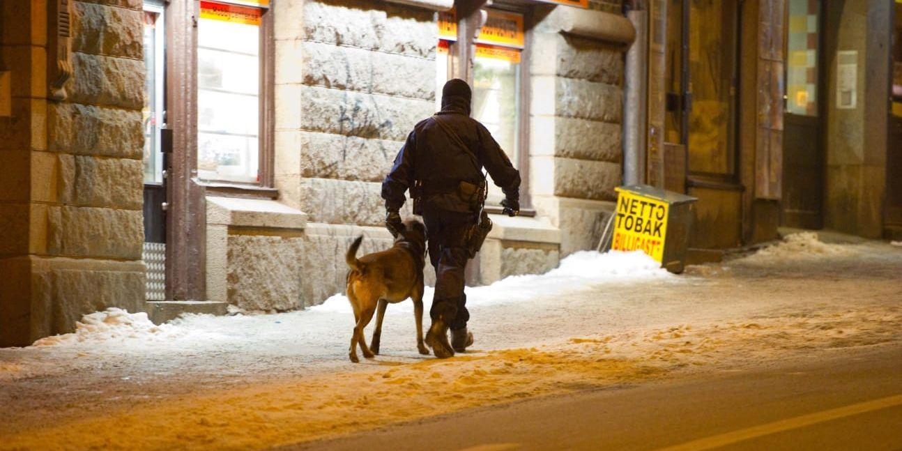 En polis och polishund letar i området efter skjutningen.