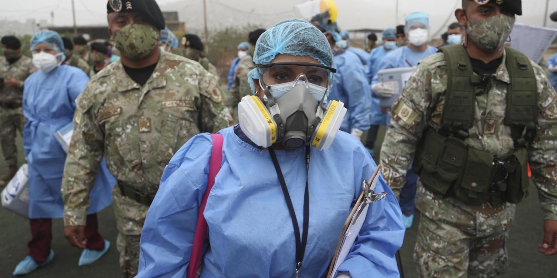 Hälsovårdsarbetare i Lima eskorteras av soldater på väg mot att testa peruaner. Bild från tidigare i januari.