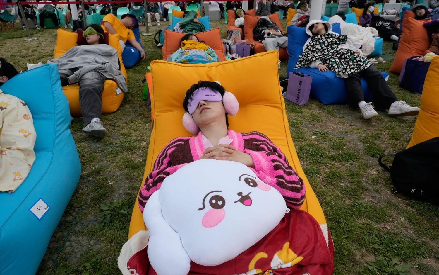 Deltagare i Seouls tupplurstävling sover i parken Yeouido Hangang på lördagen.
