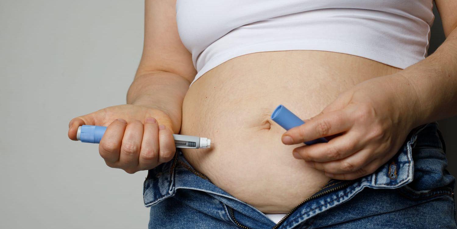 Person som tar en spruta i magen