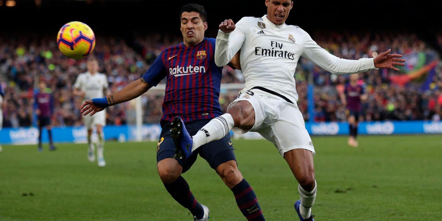 Real Madrid-försvararen Raphaël Varane, till höger, i kamp om bollen med Barcelonas Luis Suarez i El Clasico.