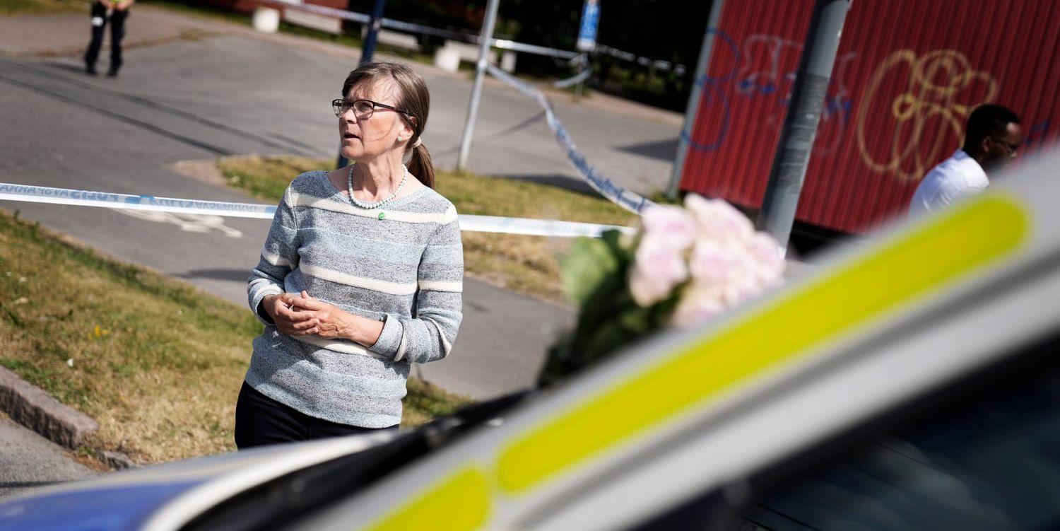 Karin Pleijel (MP) när hon lämnade blommor vid mordplatsen där en polisman sköts ihjäl under förra sommaren. 