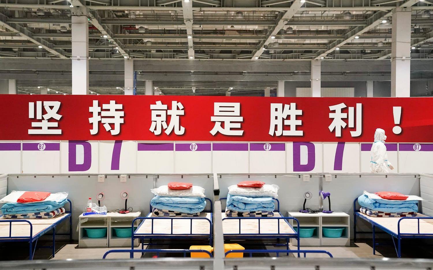 'Uthållighet innebär seger!' lyder en banderoll på på ett provisoriskt sjukhus och karantänsfacilitet i Shanghai, som har stängt ned för att stoppa smittan. Arkivbild.