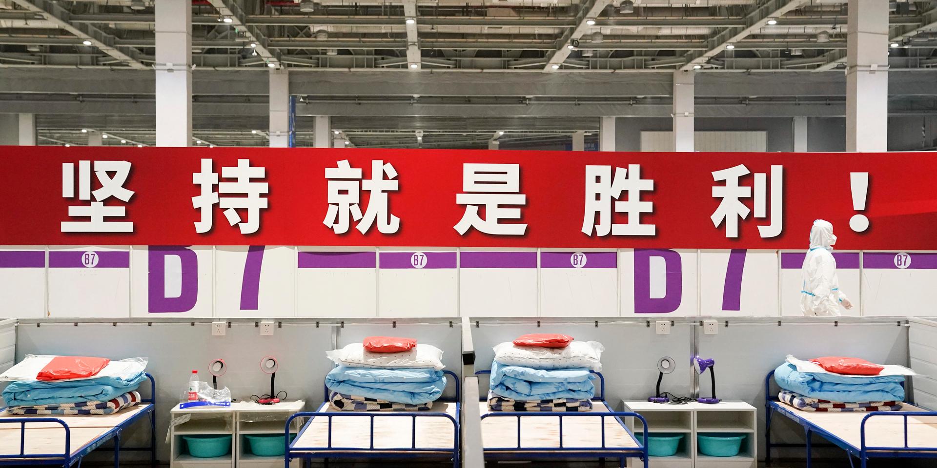 'Uthållighet innebär seger!' lyder en banderoll på på ett provisoriskt sjukhus och karantänsfacilitet i Shanghai, som har stängt ned för att stoppa smittan. Arkivbild.