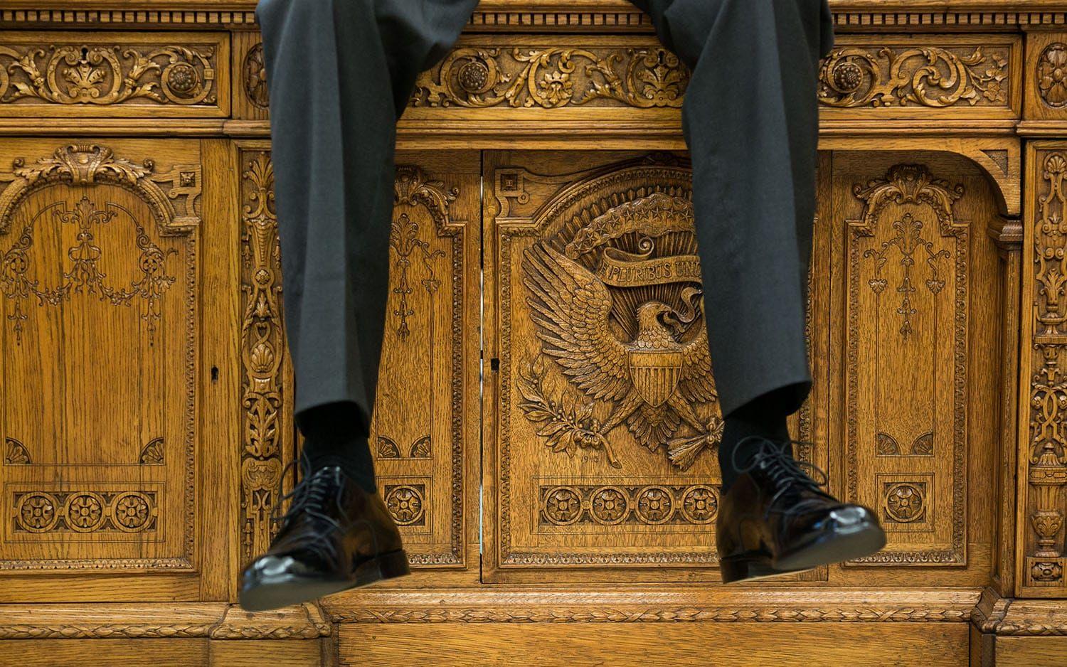 1 oktober, 2015: Obama gillar att sitta på skrivbordet i Ovala rummet. Här fångar fotografen hans dinglande ben. Foto: Pete Souza / Vita Huset