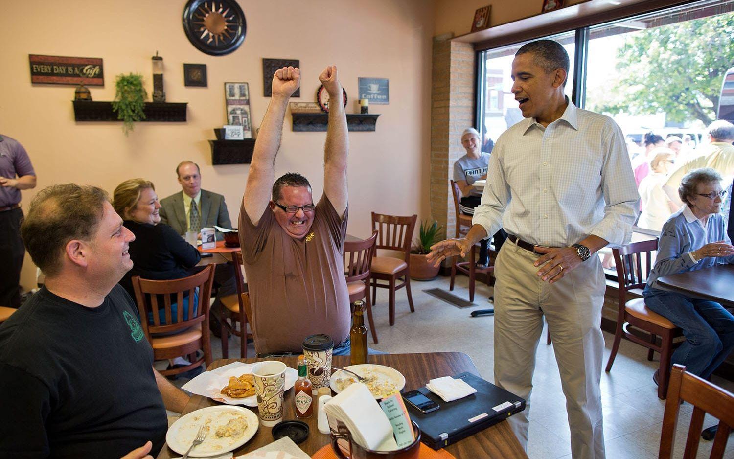 14 augusti: 2012: "Går det att få en Vita Huset-öl?" frågade en man på det café som Obama stannade till vid under valkampanjen 2012. Obama sprang ut till kampanjbussen och några minuter senare kom han tillbaka med en öl till den överlycklige mannen. Foto: Pete Souza / Vita Huset