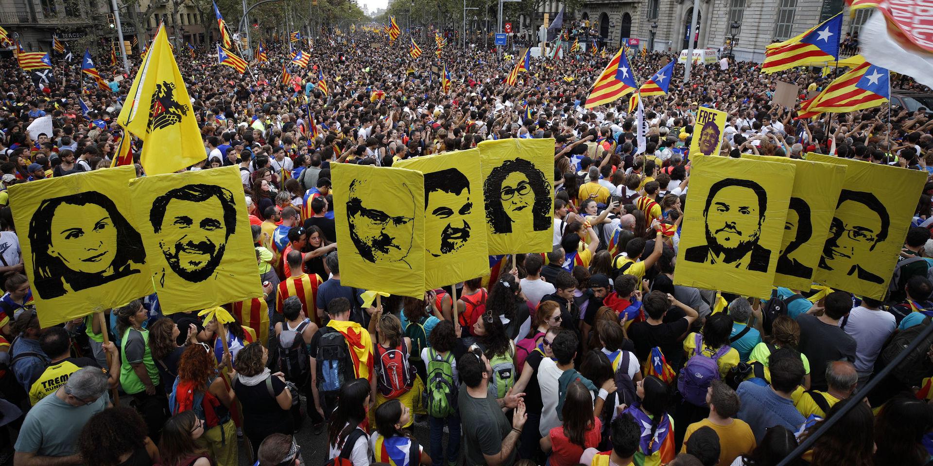 Demonstranter bär porträtt på dömda separatistledare under fredagens massprotest i Barcelona. 