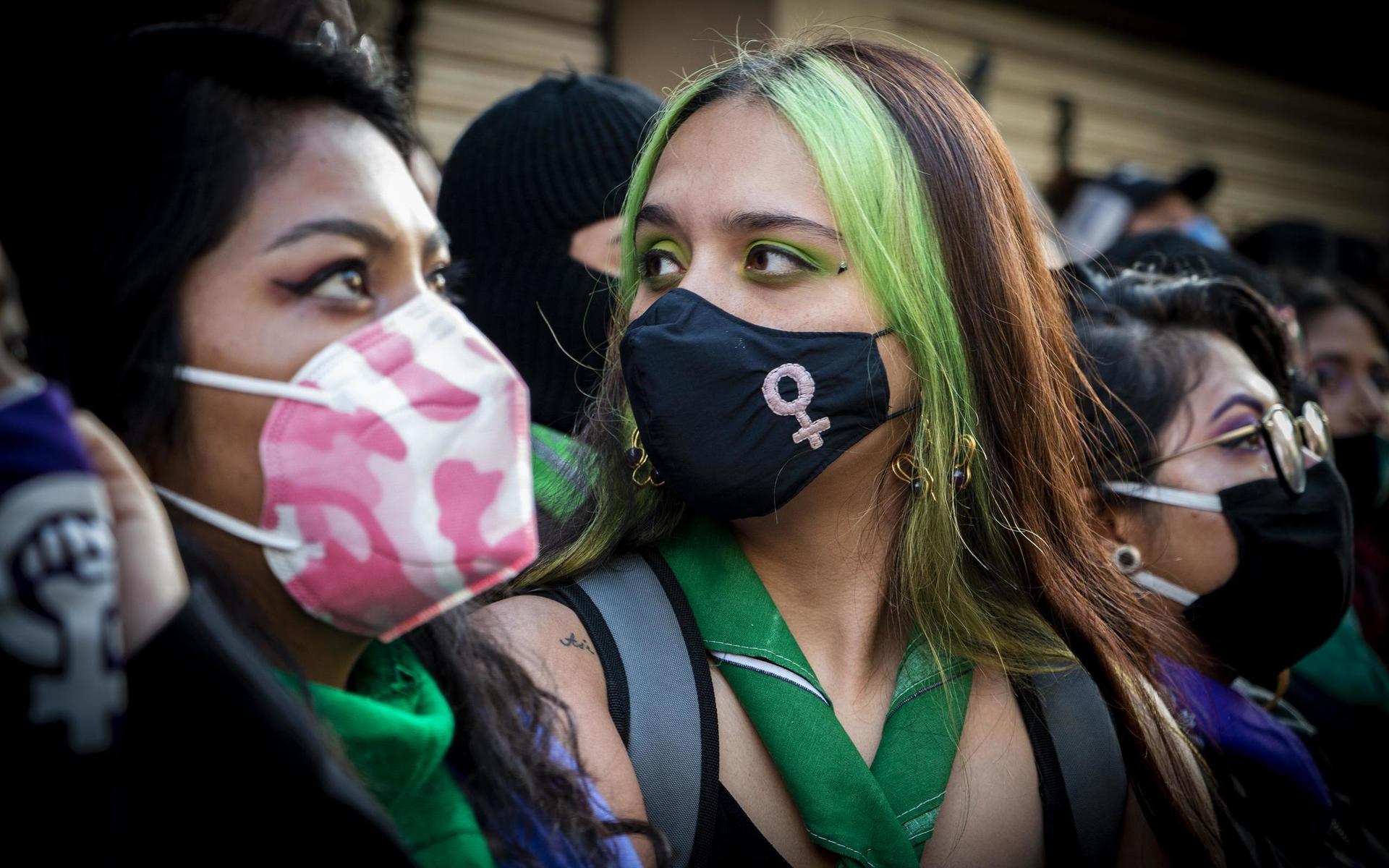 Många av kvinnorna utanför den ockuperade myndighetsbyggnaden bär munskydd eller döljer sina ansikten helt bortsett från ögonen.