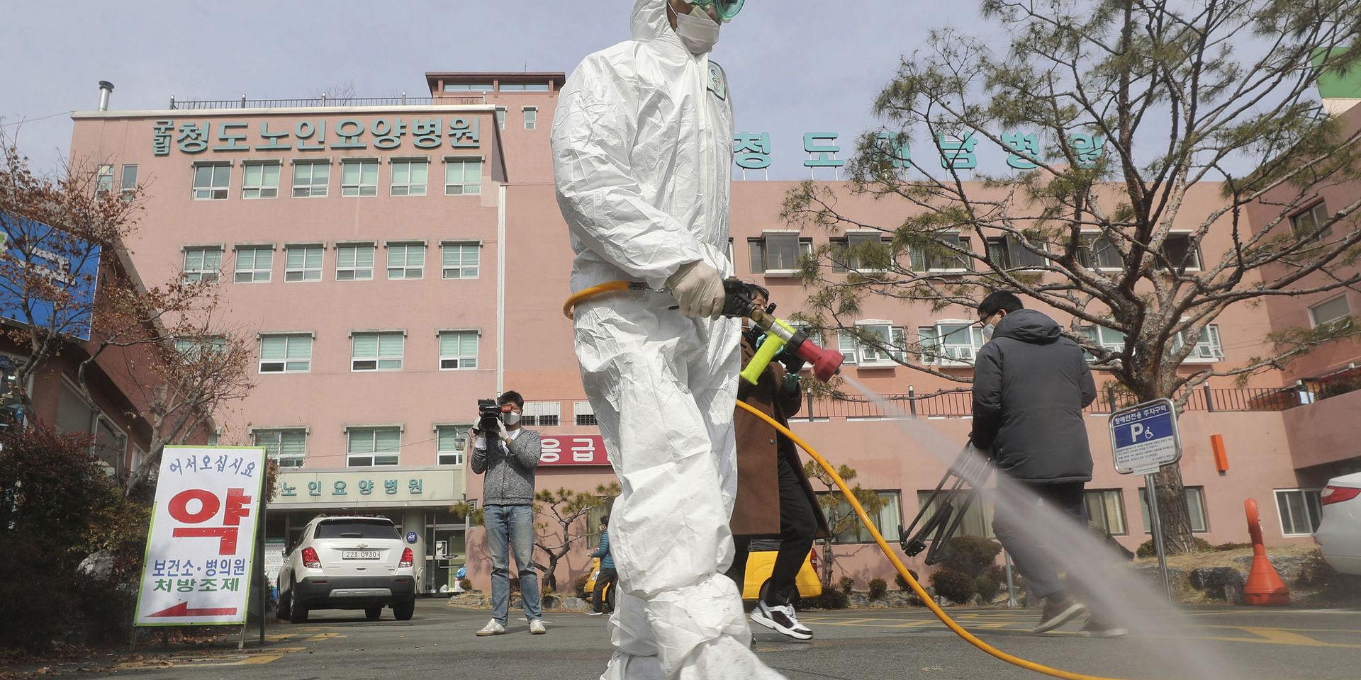 Desinfektionsmedel sprutas på gatan utanför ett sjukhus i Cheongdo i Sydkorea. 