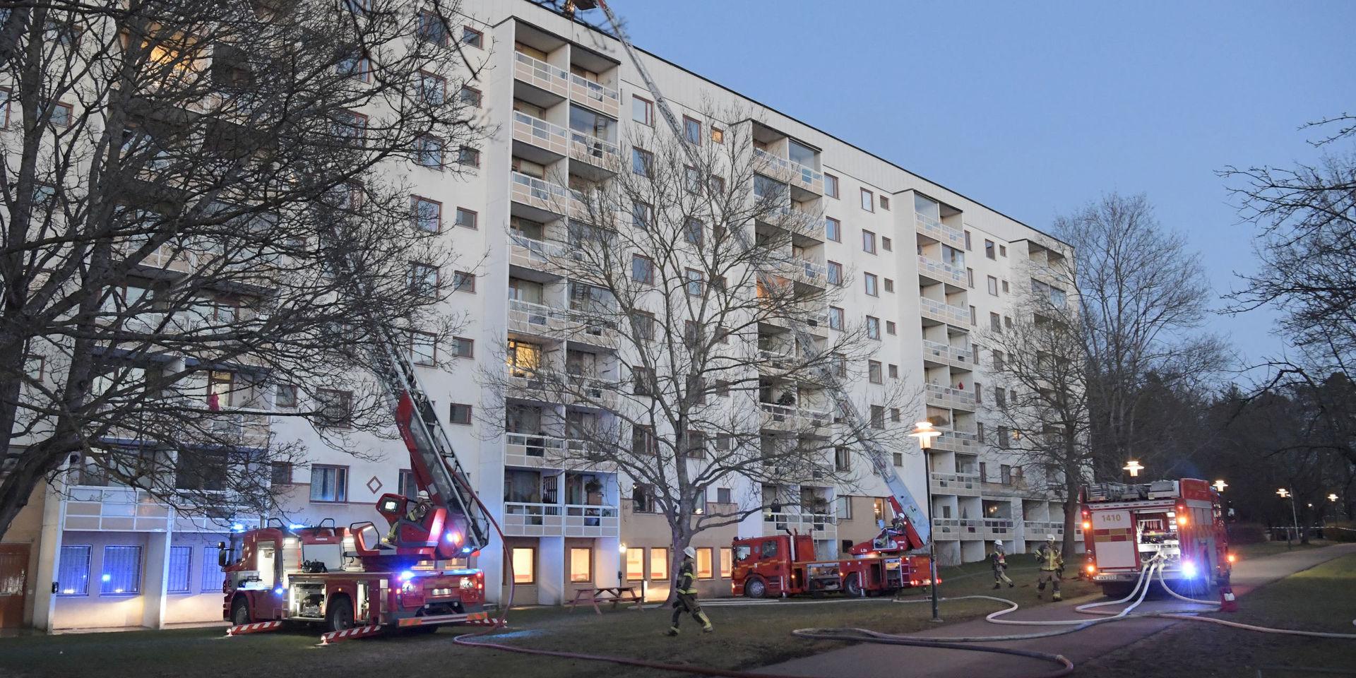 Räddningstjänsten arbetar på taket till ett åttavåningshus som började brinna i Hagsätra i södra Stockholm på söndagseftermiddagen.