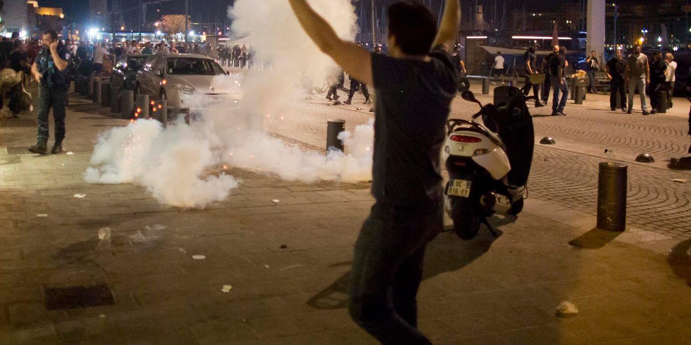 En man går mot tårgasen som fransk polis använde för att skingra bråk mellan engelska fotbollssupportrar och Marseille-bor.