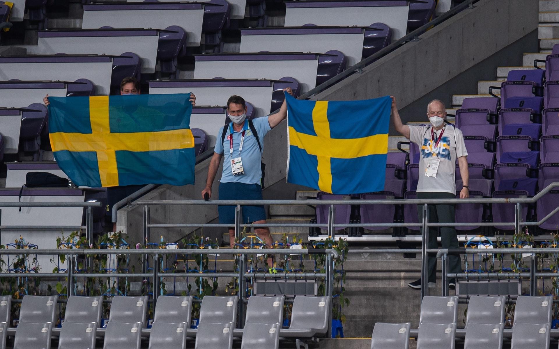 Peter Reinebo, verksamhetschef SOK, iklädd OS-kollektionen bredvid svenska flaggan visar en tydlig färgskillnad.