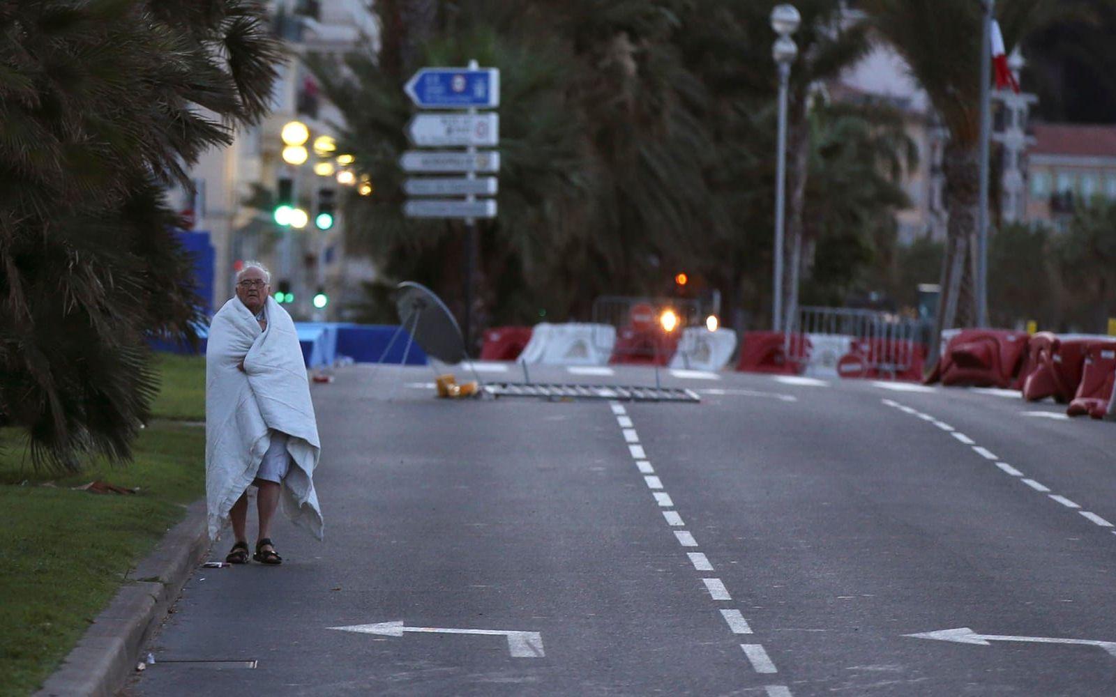 En ensam man går längs gatan morgonen efter attacken. Foto: TT