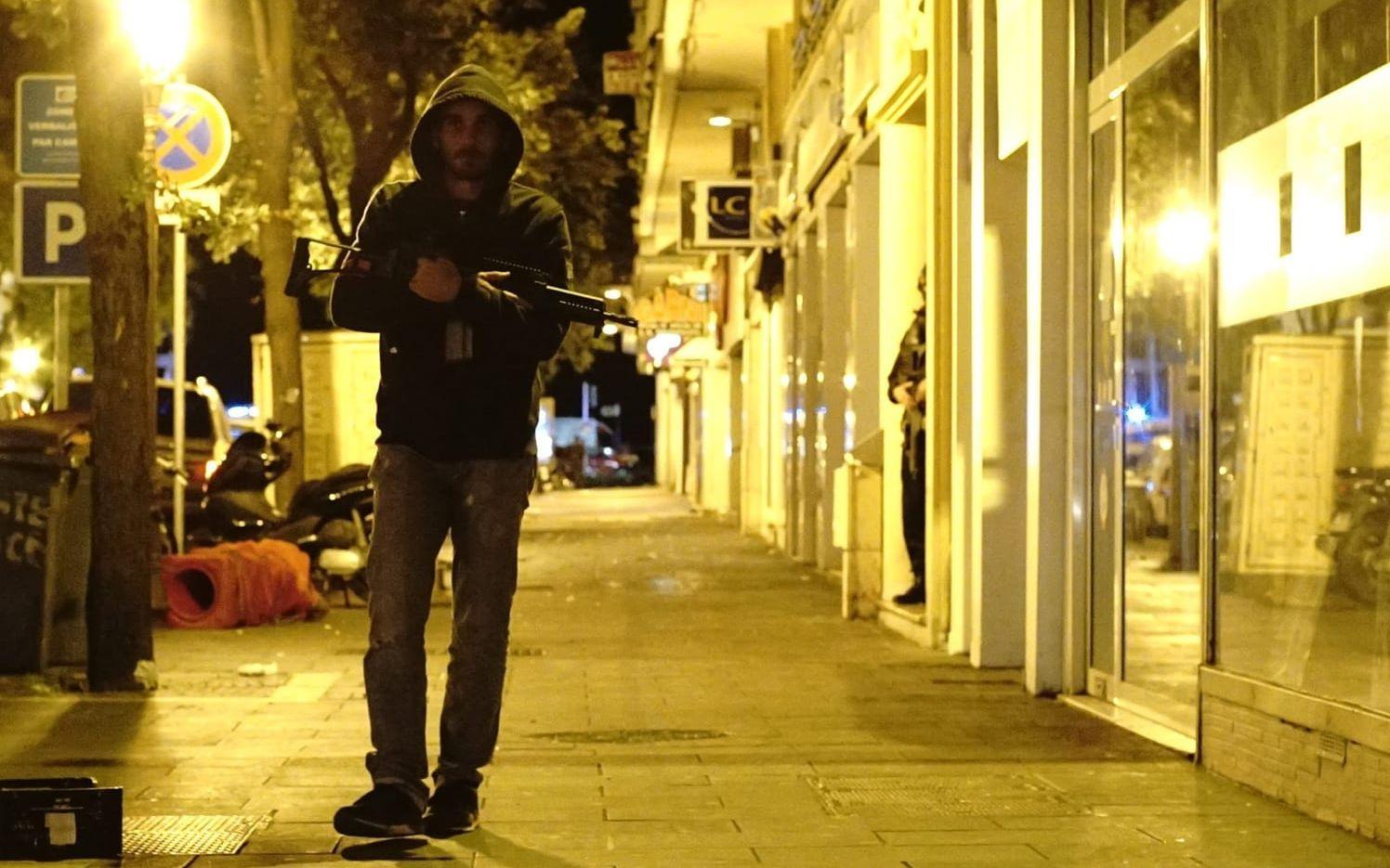 En tungt beväpnad civilpolis med patrullerar en gata i Nice. Foto: TT