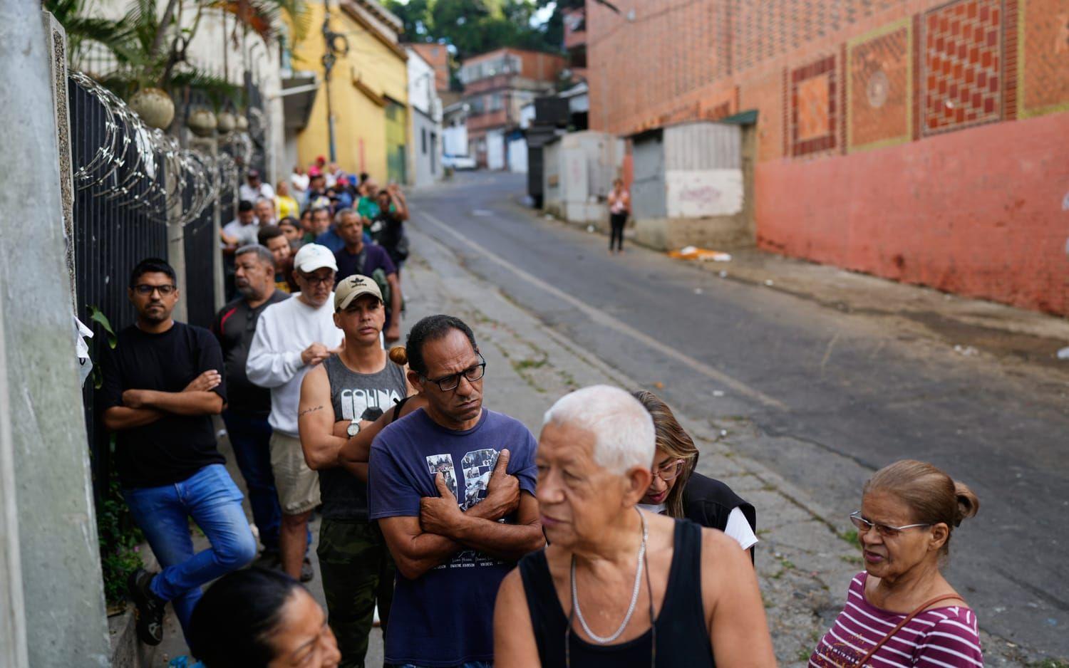 Folk köar i Caracas på söndagen. Många affärer och butiker har hållit stängt.