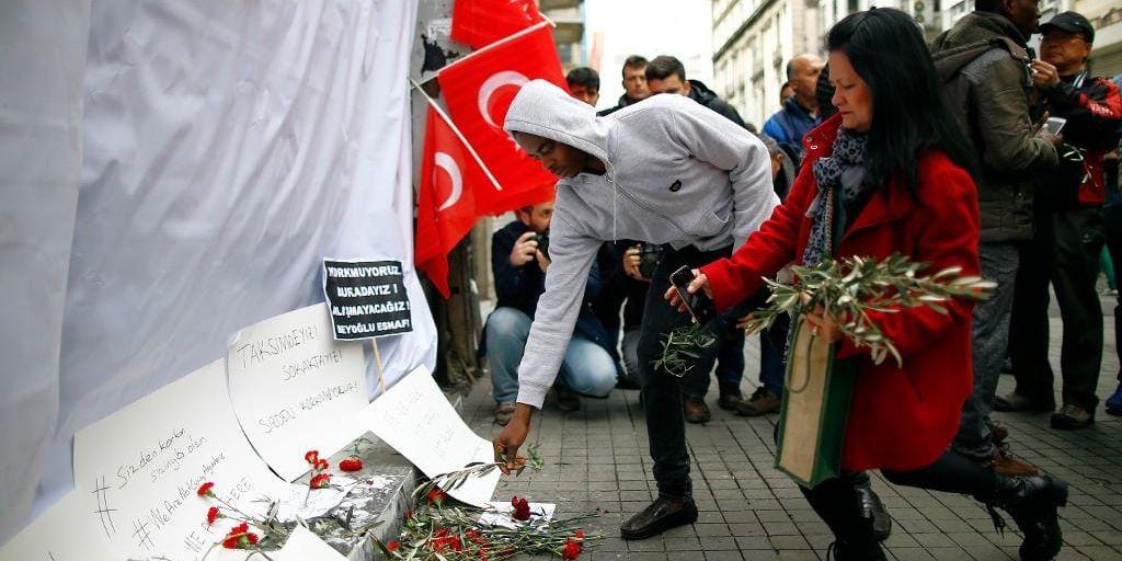 Människor lägger blommor och meddelanden för att hedra dödsoffren vid platsen för lördagens terrorattack i Istanbul.
