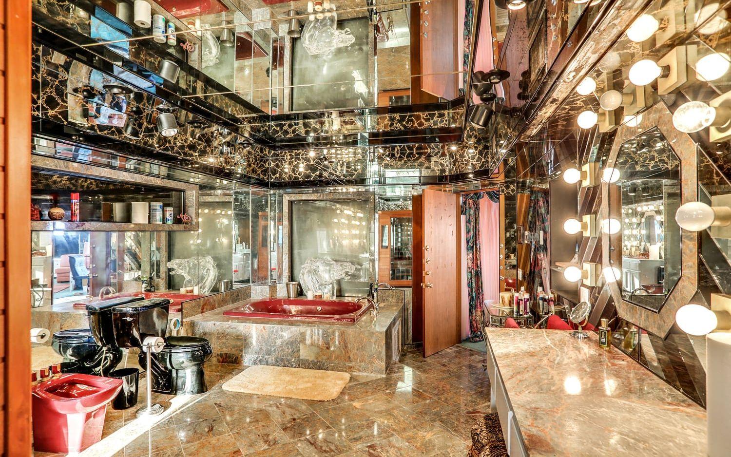 Det här badrummet tillhör master suite. Det har fått en udda inredning med speglar i taket, en  bubbelpool, bidé och tvättställ i rött och en svart toalett. När man ligger i badet håller ett stort glasdjur en sällskap.