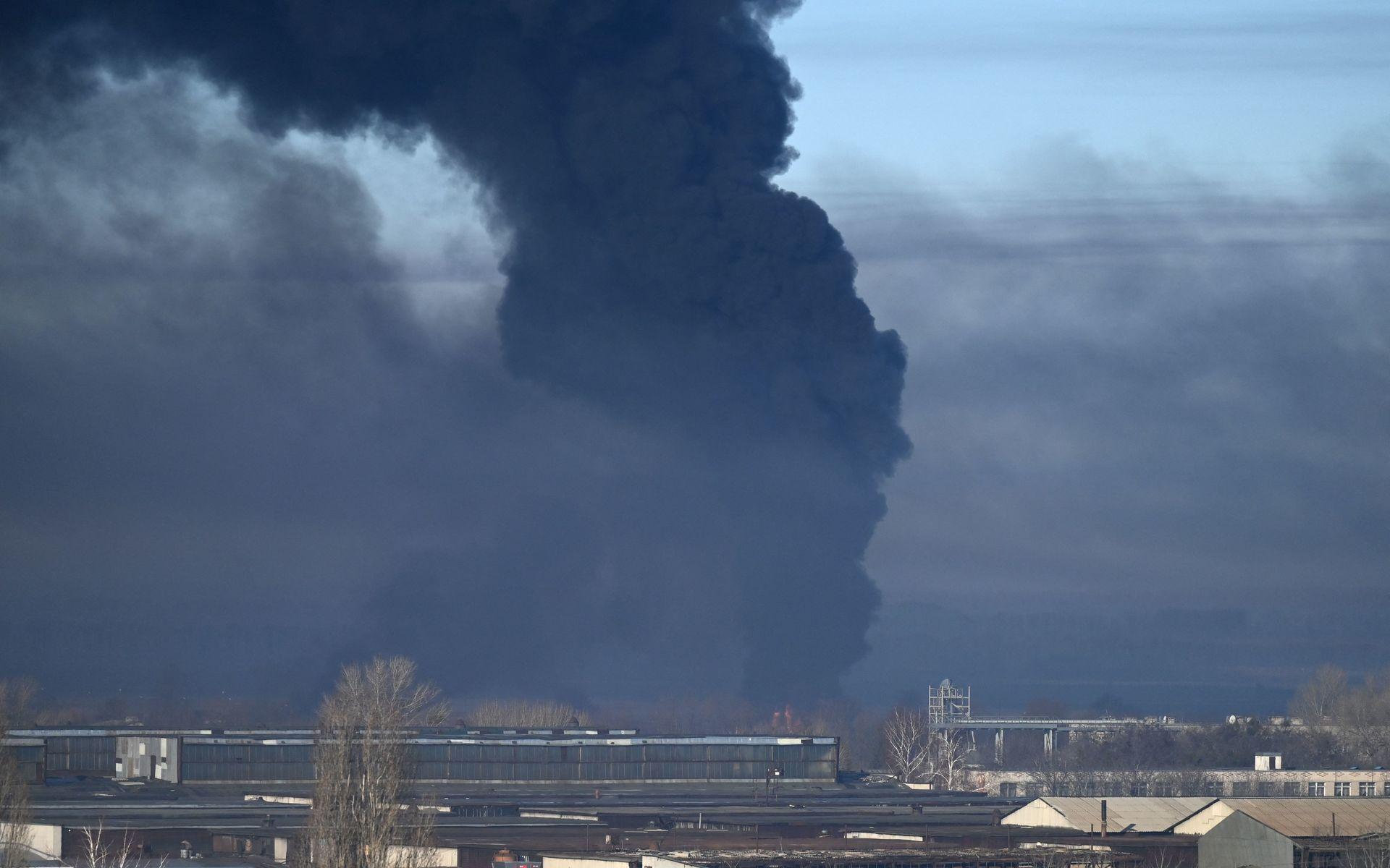 Svart rök stiger från en militärflygplats i staden Tjuhujiv, som ligger strax utanför miljonstaden Charkiv i östra Ukraina på torsdagsmorgonen.