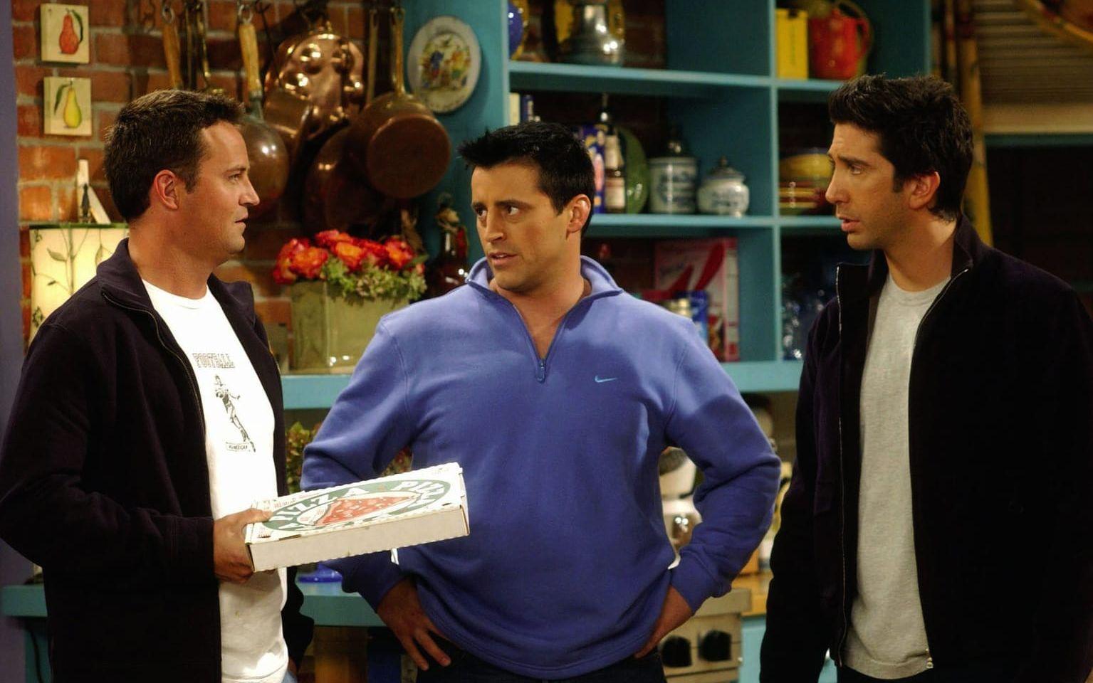 Stillbild från ett avsnitt av ”Vänner”. Karaktärerna Joey, Chandler och Ross i köket till lägenheten där det mesta av serien utspelade sig.