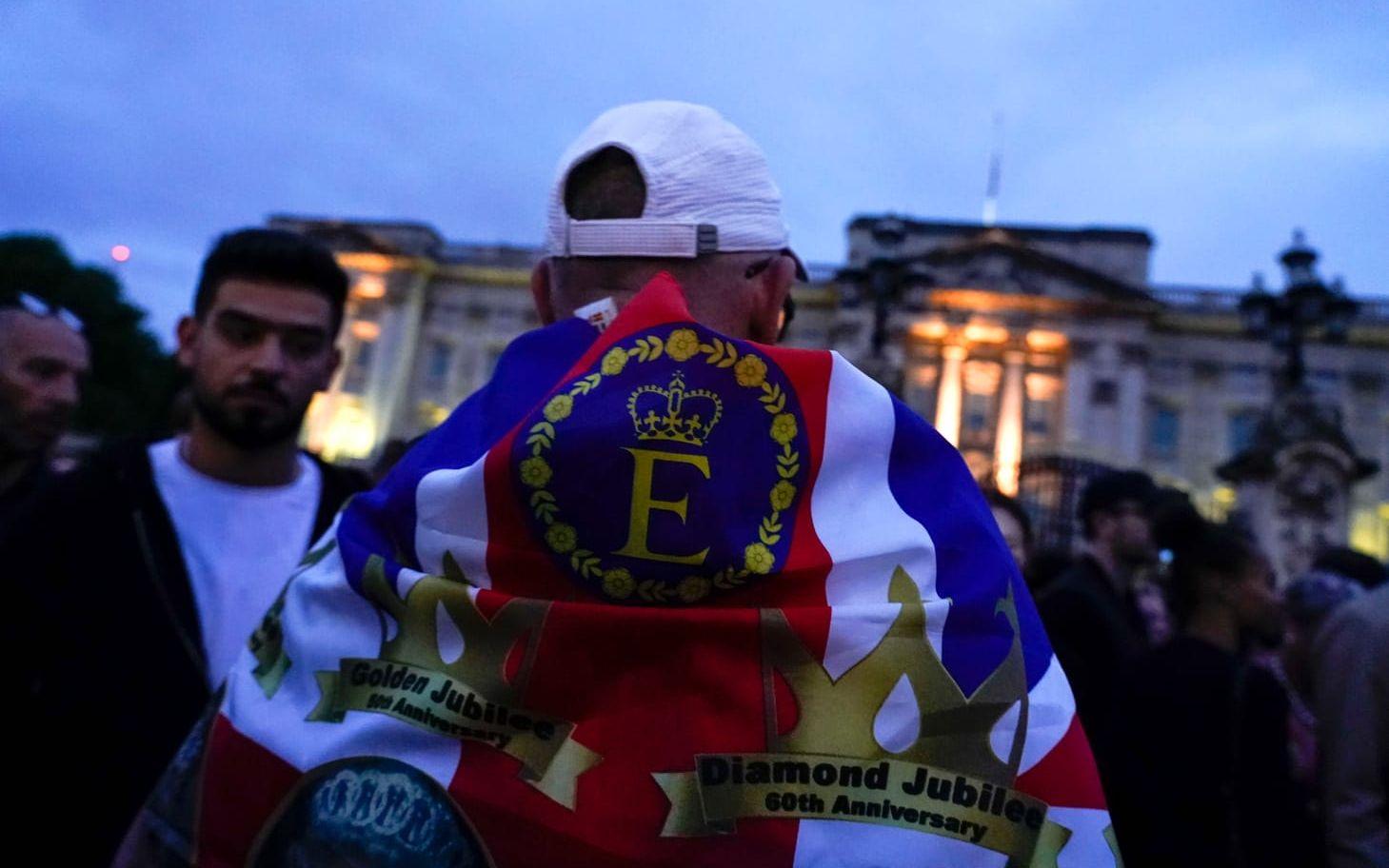 En man med Union Jack med märken från drottningens olika jubileum. 