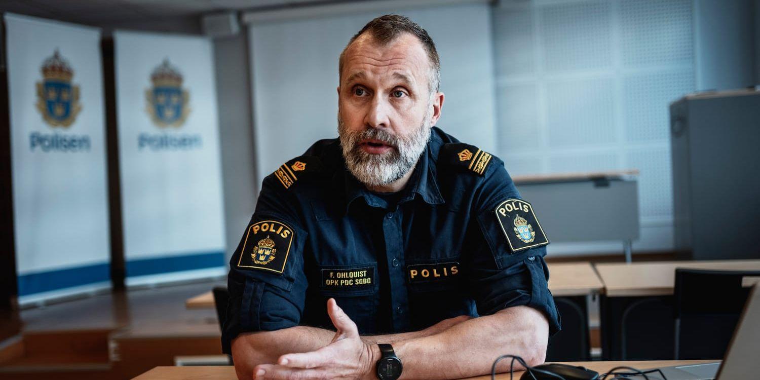 En polis i uniform pratar vid ett skrivbord.