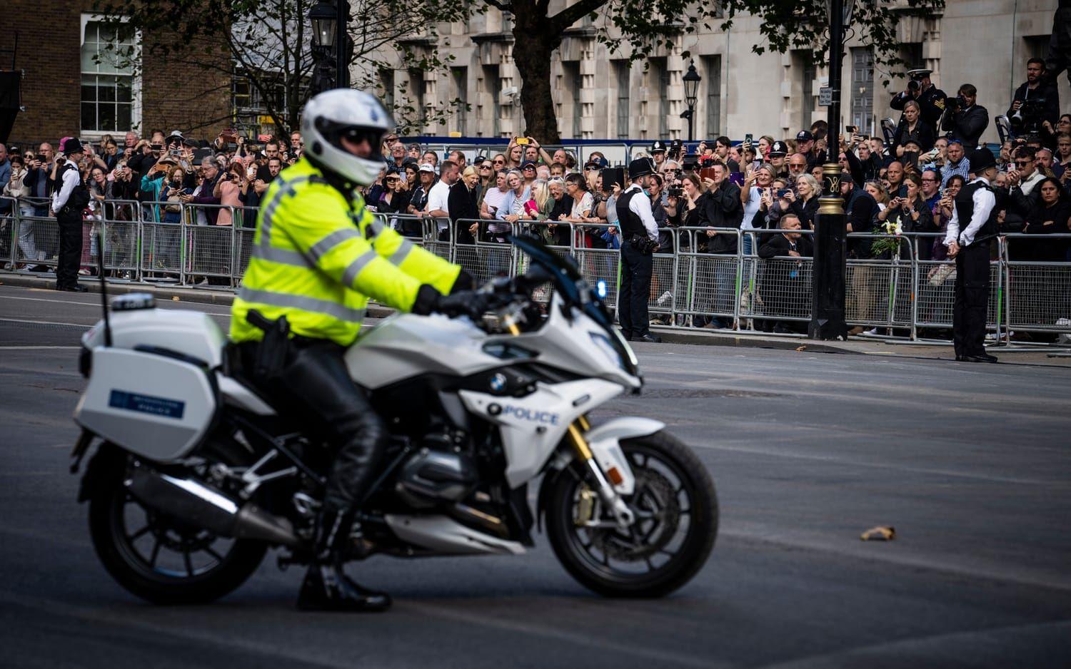 Ett stort antal poliser bevakar processionen från Buckingham Palace till Westminster Hall. 