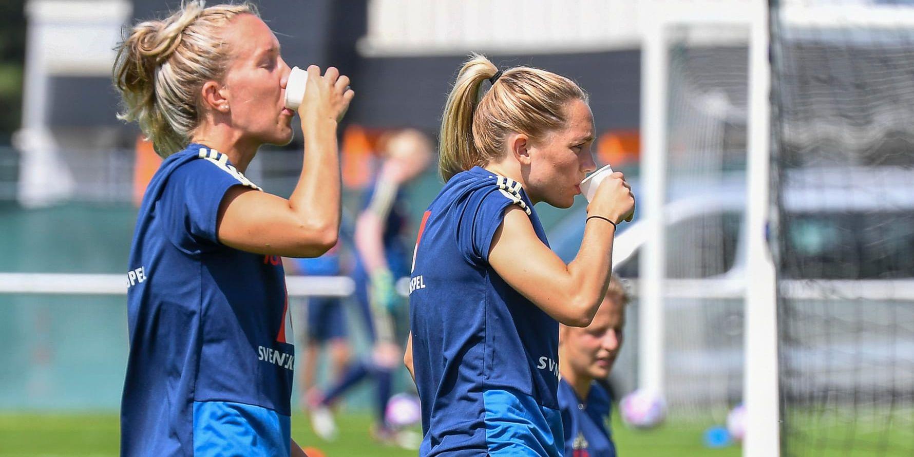 Julia Roddar och Elin Rubensson tar en drickpaus i den 30-gradiga värmen när det svenska fotbollslandslaget tränar i Fougères utanför Rennes inför VM-kvartsfinalen mot Tyskland på lördag.