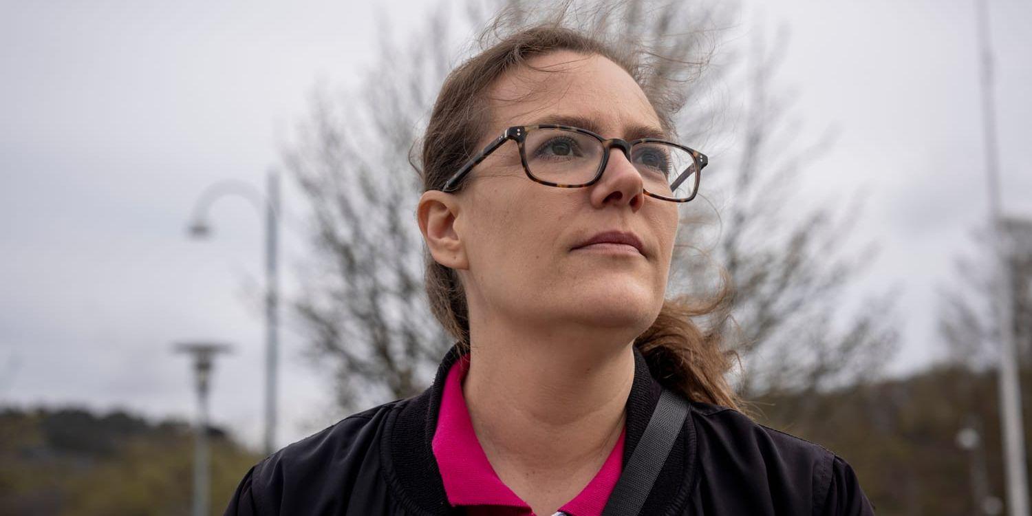 En kvinna med glasögon i utomhusmiljö.