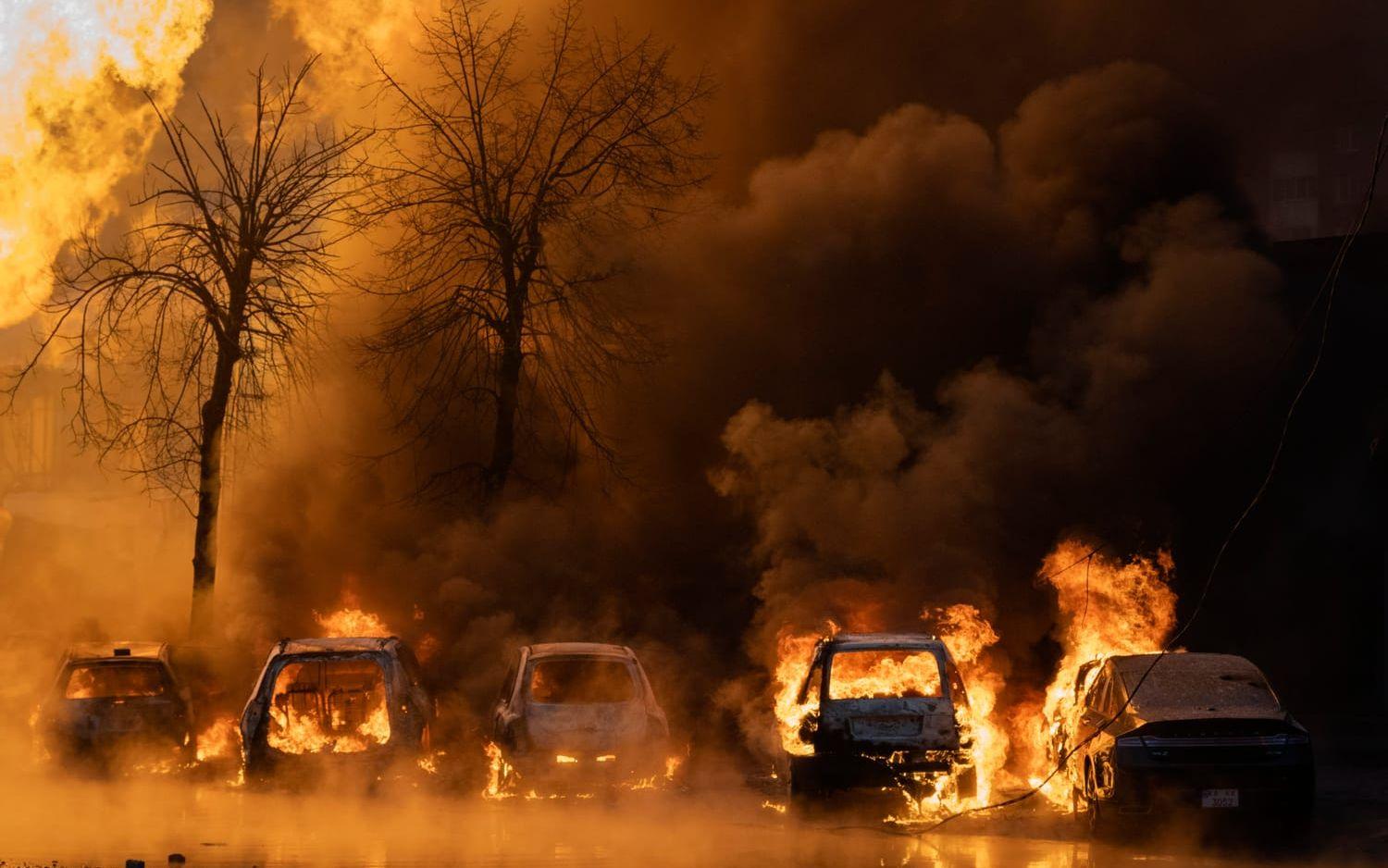 Bilar brinner i Kiev efter en rysk attack.