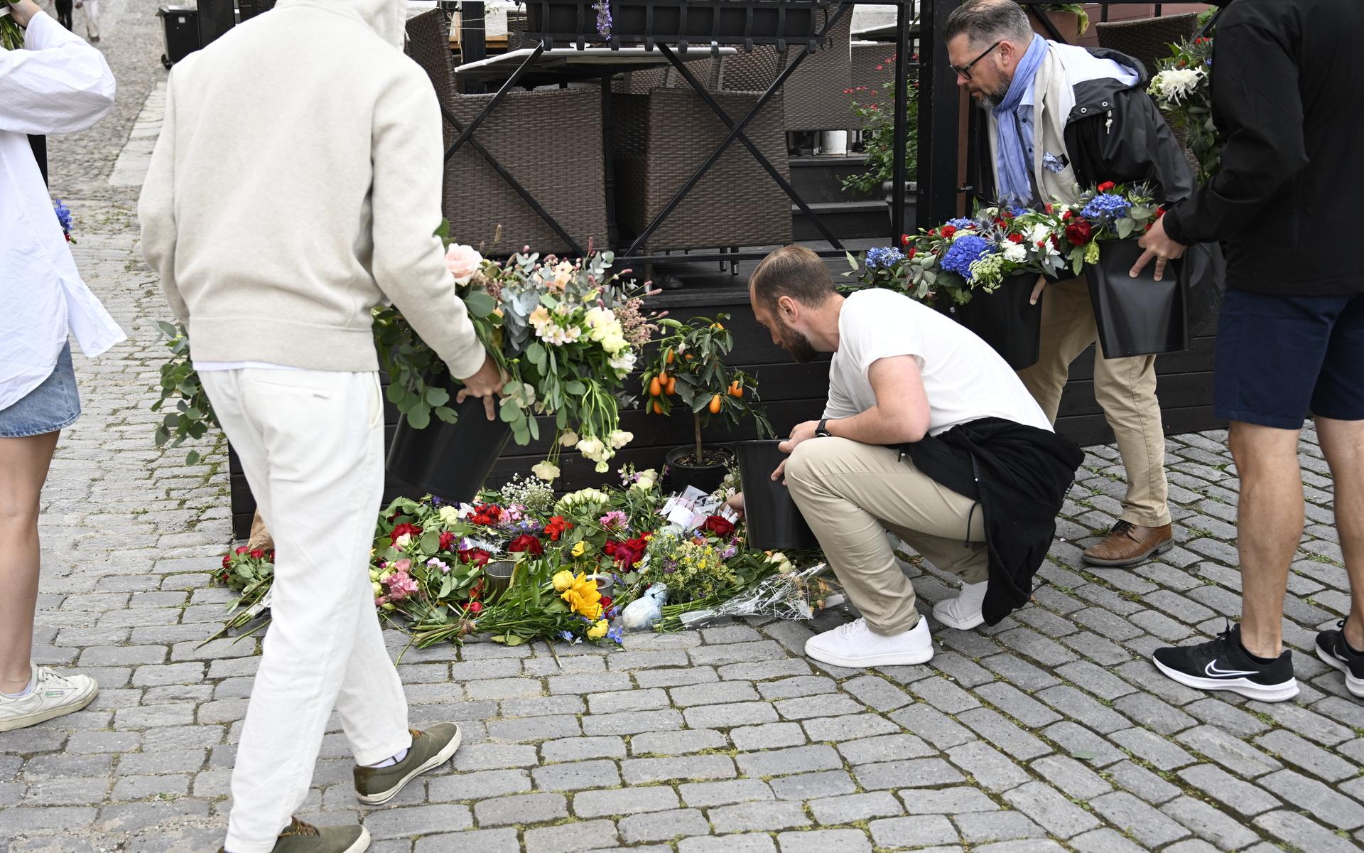 Personer lägger ned blommor vid Donners plats i Visby, där Ing-Marie Wieselgren