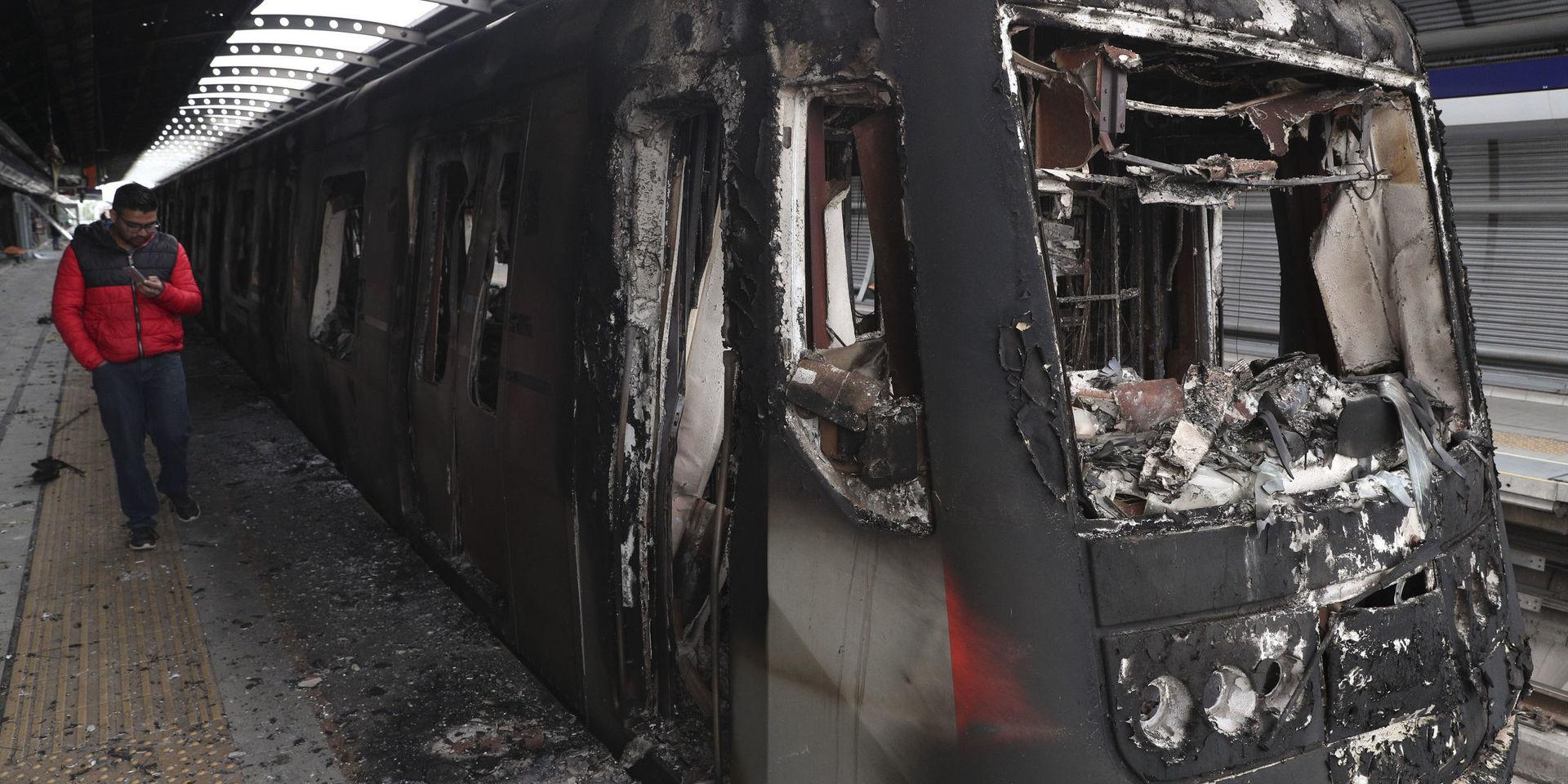 Flera bränder har anlagts i samband med protesterna i Santiago. Här är en tunnelbanevagn som har bränts. 
