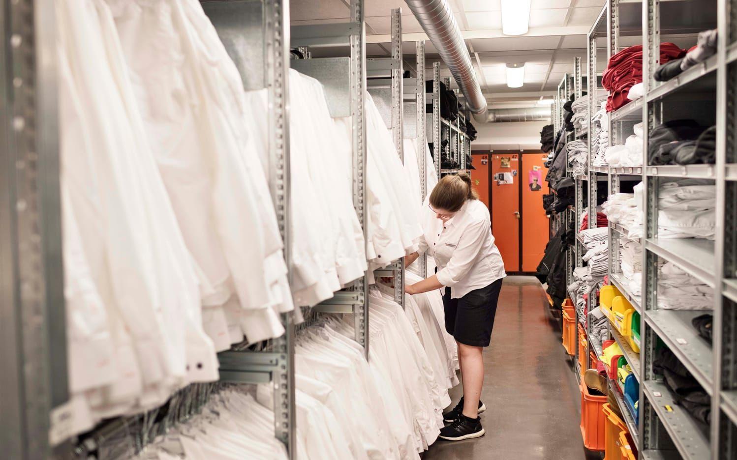 Maria Dristig bläddrar vant bland de rena vita skjortorna som finns på Lisebergs Kläderi. Över 10 000 plagg hänger här, uppskattar hon. Bild: Erik Abel