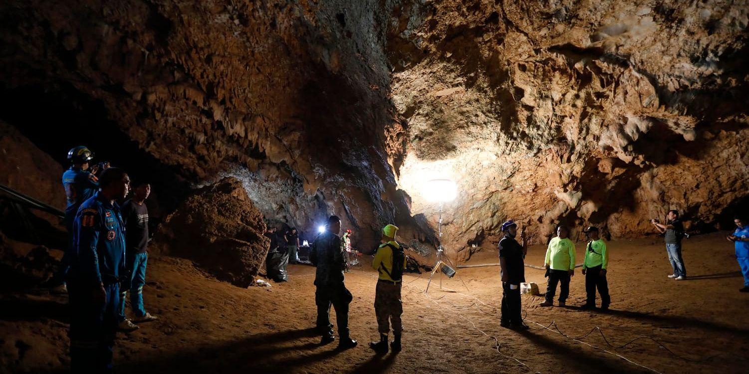 Räddningsarbetare söker av den grotta där 13 personer tros befinna sig efter att de anmälts saknade i lördags. Stora delar av grottan är översvämmad efter kraftigt monsunregn i området.