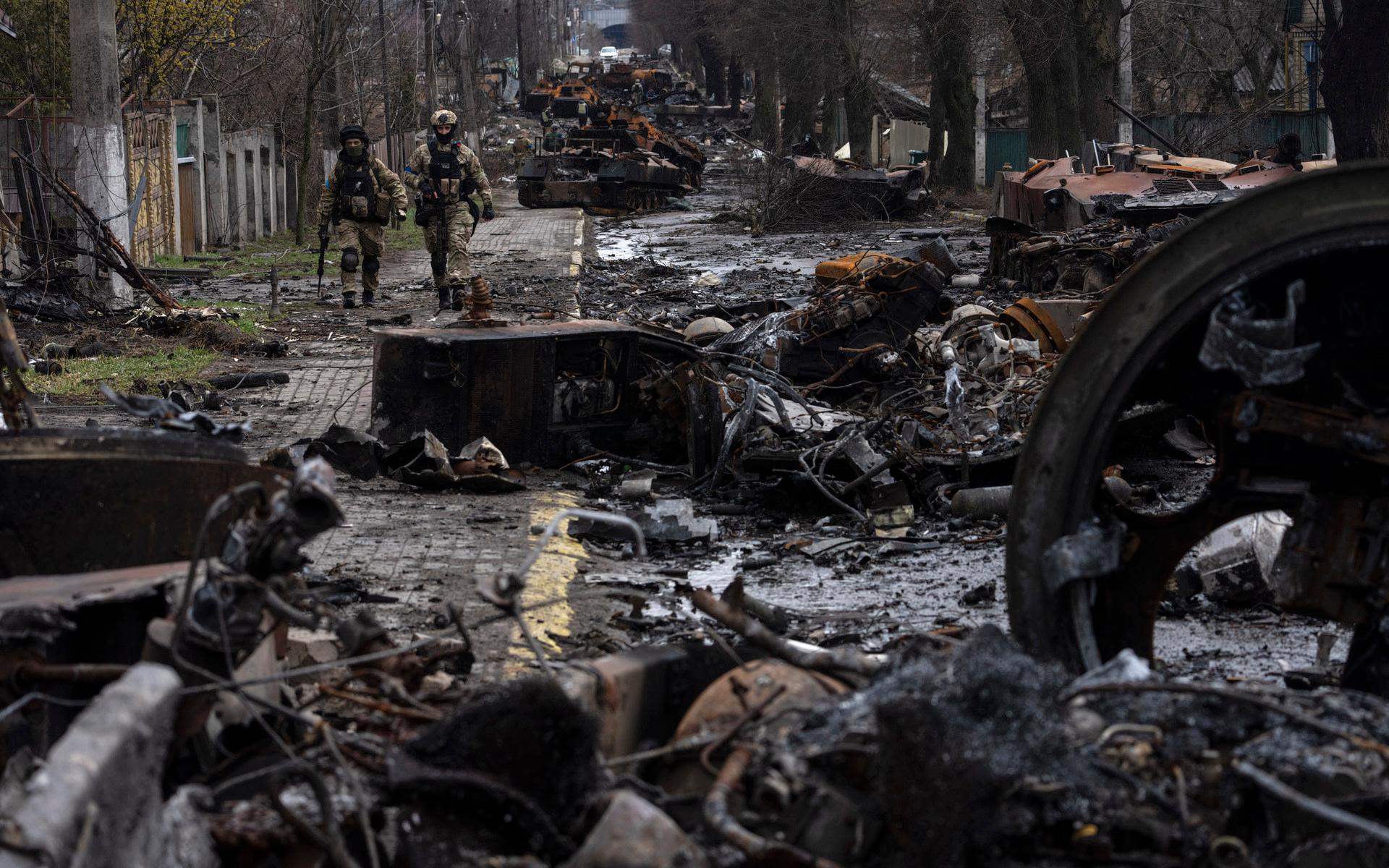 Soldater går bland förstörda ryska militärfordon som blivit kvar i staden.