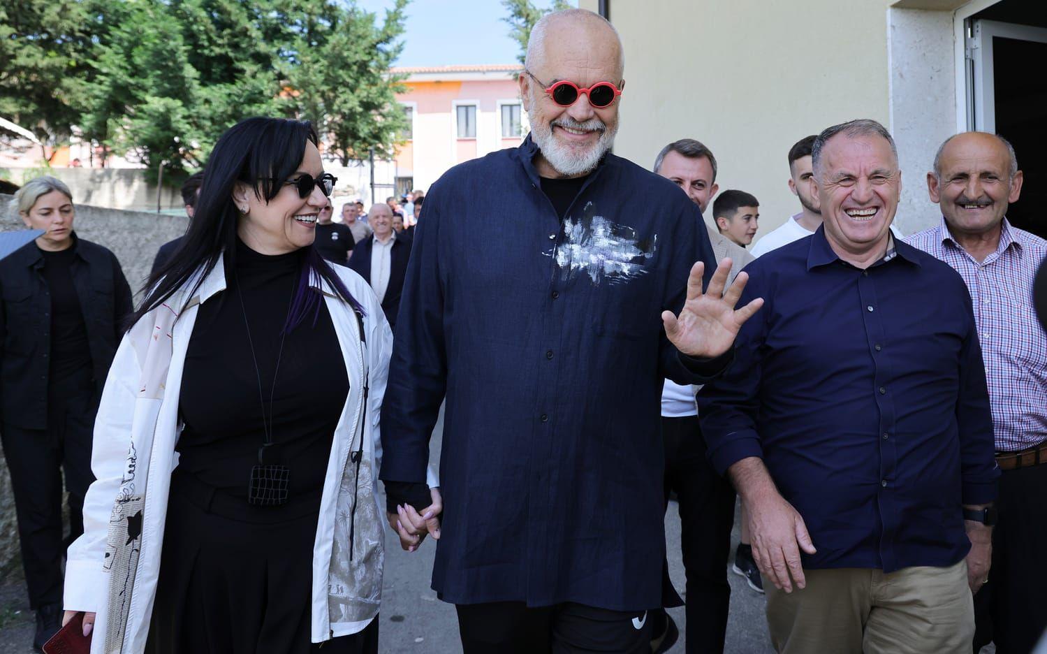 Albaniens sittande premiärminister Edi Rama (mitten) lämnar en vallokal tillsammans med sin fru på söndagen.
