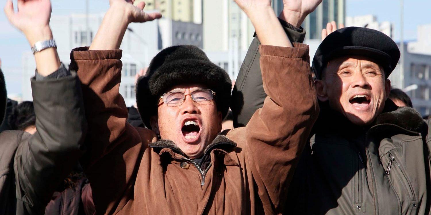 Människor jublar i Pyongyang när de ser nyhetssändningen som bekräftar att en internkontinental robot skjutits upp.