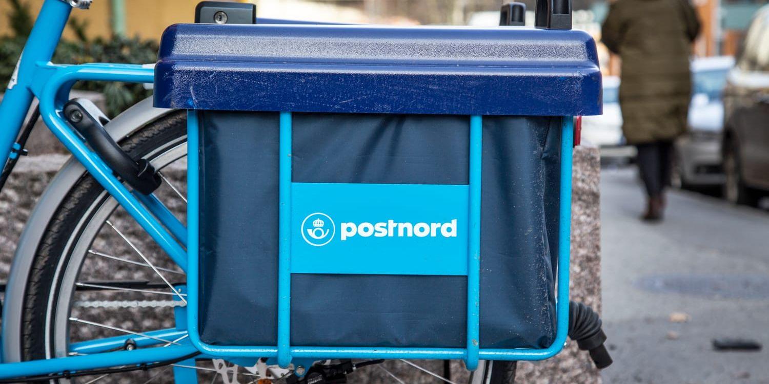 Närbild på cykelväska med Postnord-logga och bakre cykelhjul.