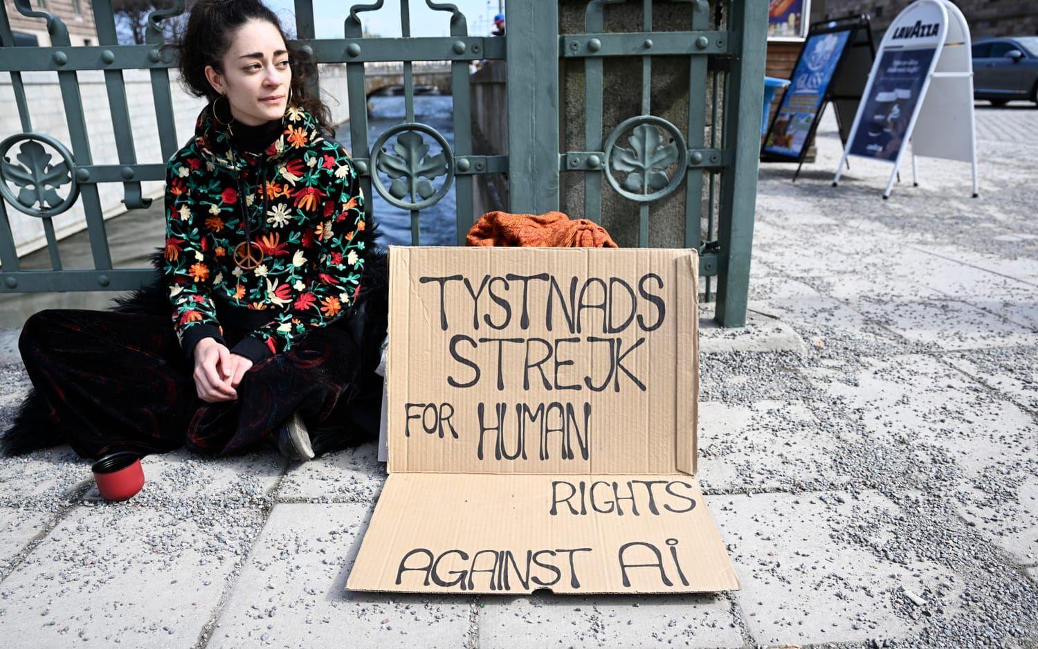 En ung kvinna demonstrerar för mänskliga rättigheter mot AI, artificiell intelligens, och riskerna som den nya AI tekniken för med sig. 