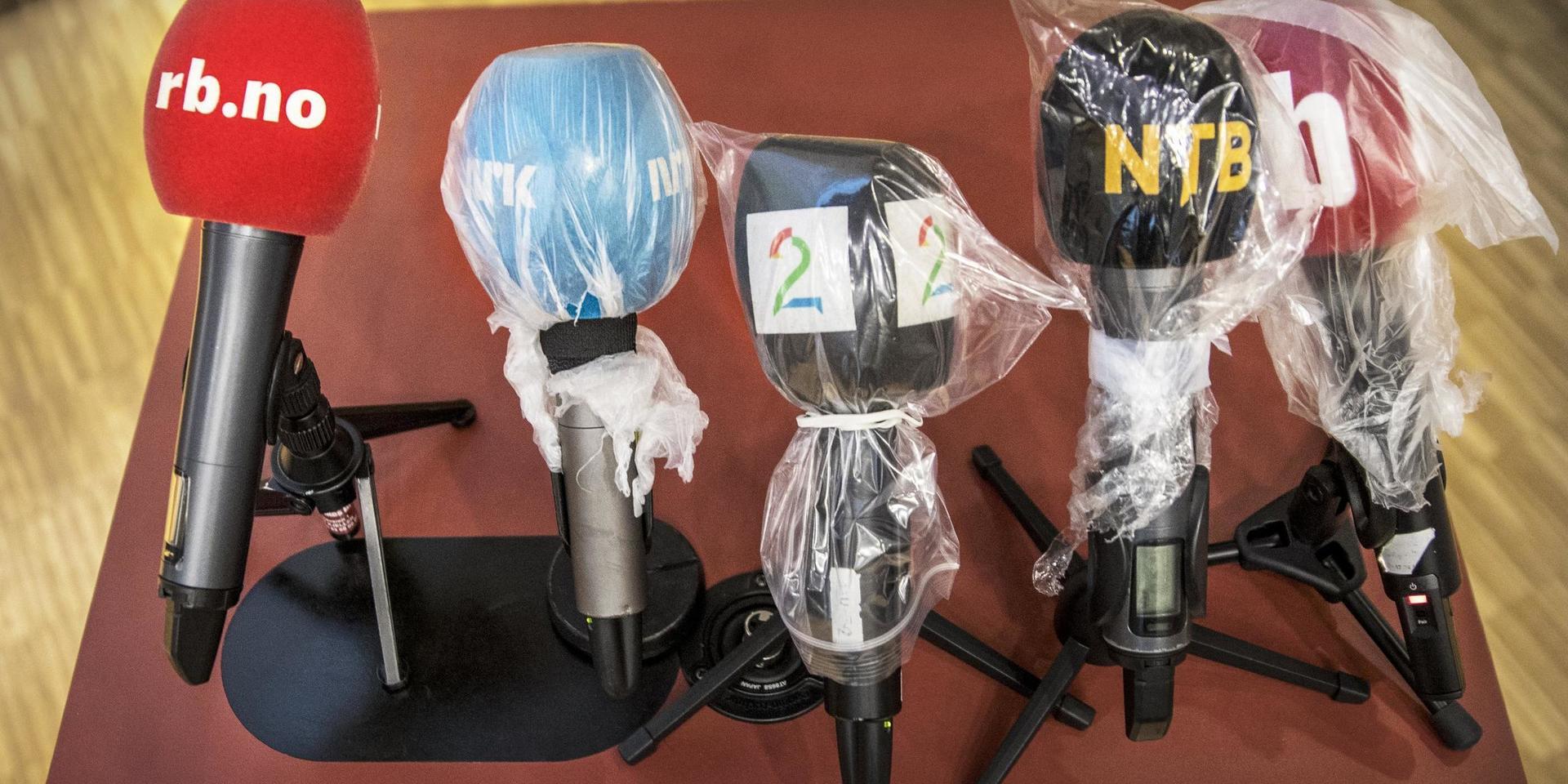 Inplastade mikrofoner vid en norsk presskonferens.